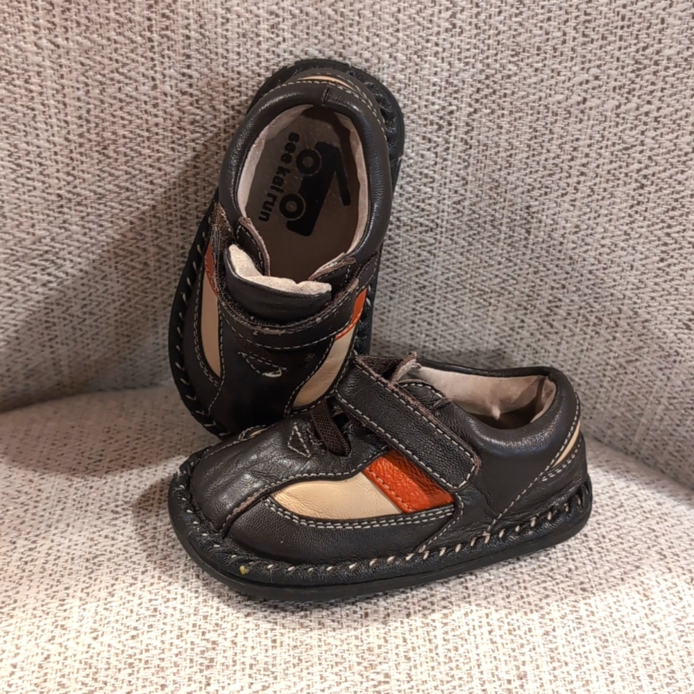 Leather toddler shoes with burnt orange accent stripe. Has some mild wear.